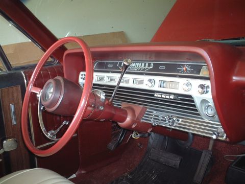 1967 Ford Galaxie - The interior of a 1967 Ford Galaxie, a red steering wheel, dashboard, and seating.