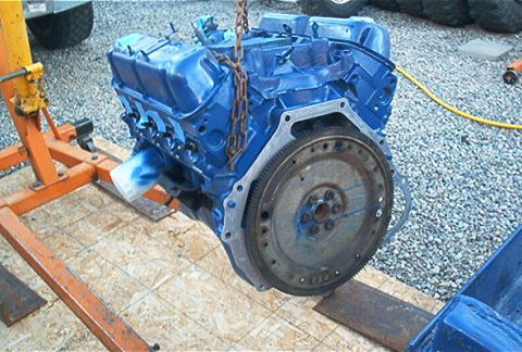 1986 Ford Bronco - Engine block painted blue, being lifted by an engine hoist.