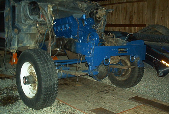 Blue engine in disassembled vehicle chassis