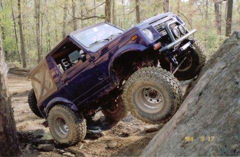 1978 Ford Bronco - A purple Suzuki Samurai navigates a challenging rocky terrain during an off-road excursion.