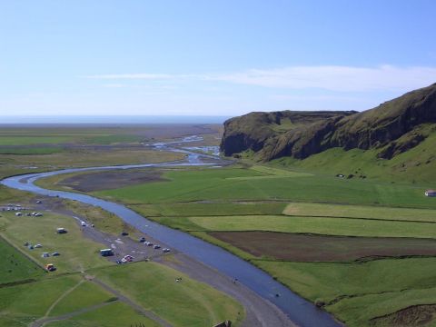 1996 Ford Bronco - A scenic landscape features a river flowing through cultivated fields, bordered by a dramatic cliff face and the distant sea.