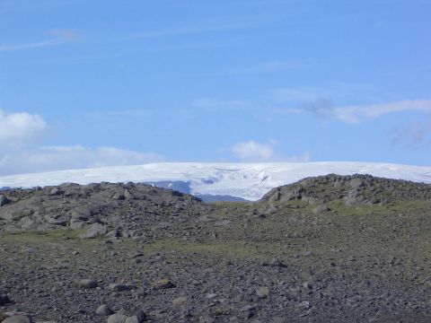 1996 Ford Bronco - A vast, rocky terrain stretches towards a distant glacier under a clear blue sky.