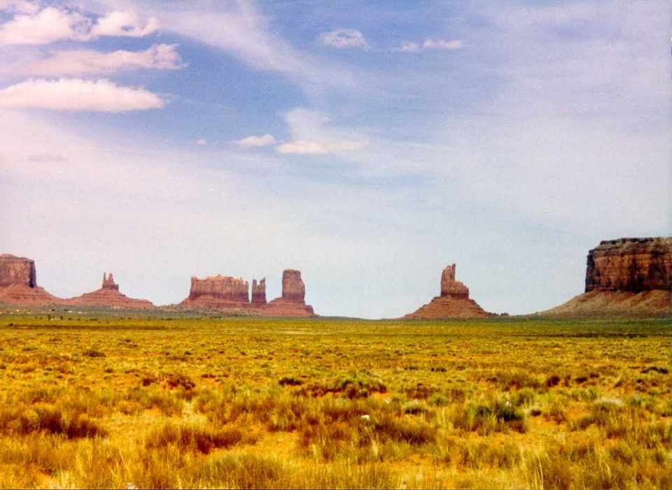 Monument Valley landscape with mesas and dry grass under a cloudy sky