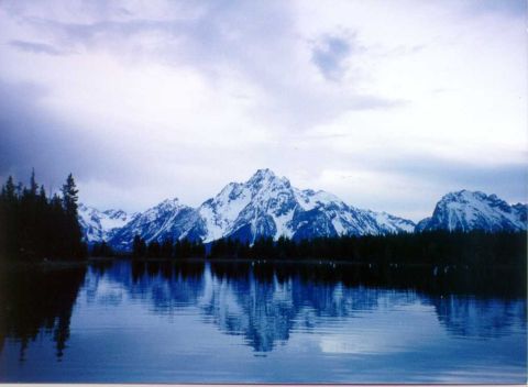 1996 Ford Bronco - A mountain landscape with snow-capped peaks reflected in the still waters of a lake.
