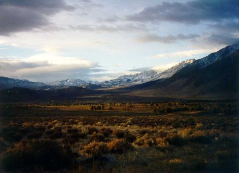 1996 Ford Bronco - Expansive mountain landscape with snow-capped peaks and a cloudy sky.