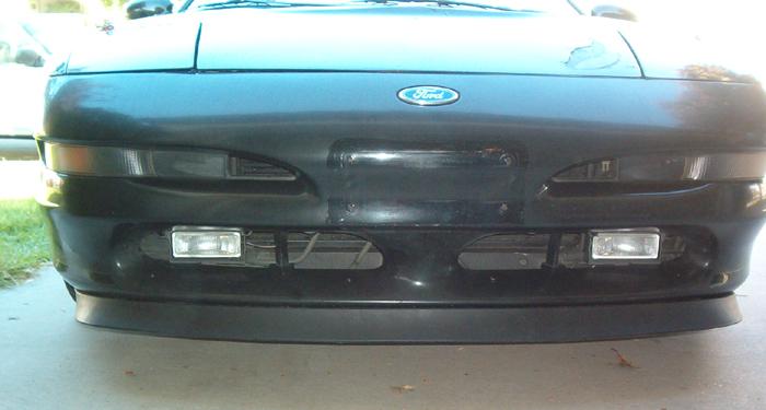 Close-up of a black Ford Probe front bumper with Ford emblem and lower driving lights
