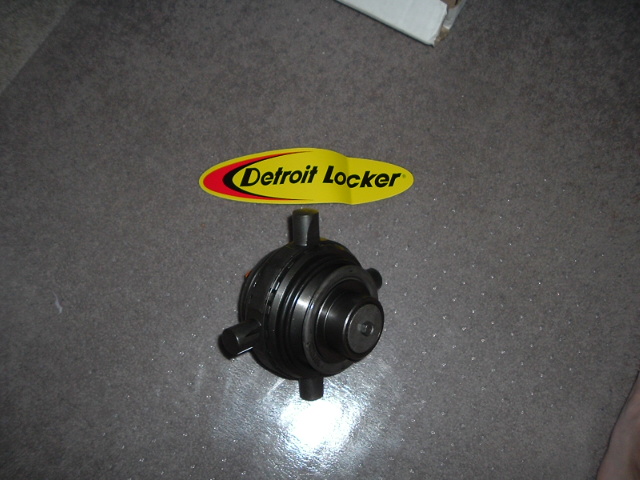 Detroit Locker differential unit on the floor next to a yellow Detroit Locker decal