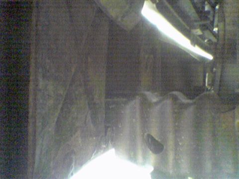 1993 Ford Bronco - A dark, grainy photo shows the underside of a vehicle, with some parts obscured by shadow and glare.