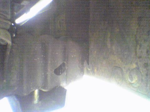 1993 Ford Bronco - A close-up view of an unidentified undercarriage part, possibly from a vehicle, with a bright light source illuminating the scene.