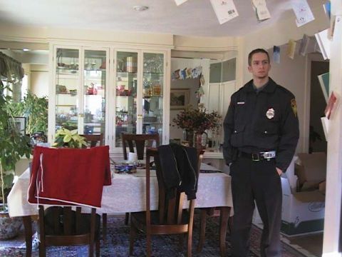 2000 Jeep Liberty - A man in a security uniform stands in a room with a dining table and a large china cabinet.