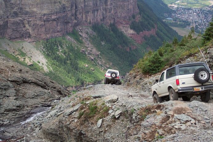White Ford Bronco on a rocky mountain trail, rear view
