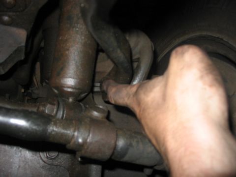 1988 Ford Bronco - A hand is shown adjusting a sway bar connection on a vehicle's suspension system.