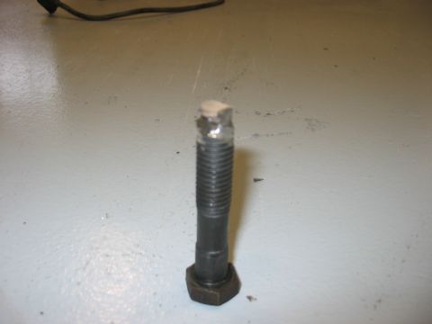 1988 Ford Bronco - A single bolt with a nut is shown on a light gray surface, with a Supermotors logo in the corner.