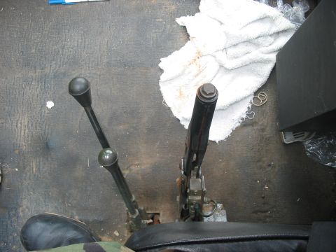 1988 Ford Bronco - Close-up of the floor console area in a vehicle, showing two levers and a white towel.