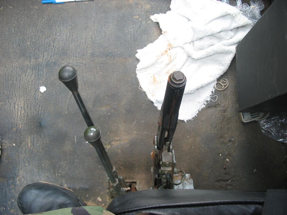 Interior view of vehicle floor with two black levers and a white towel