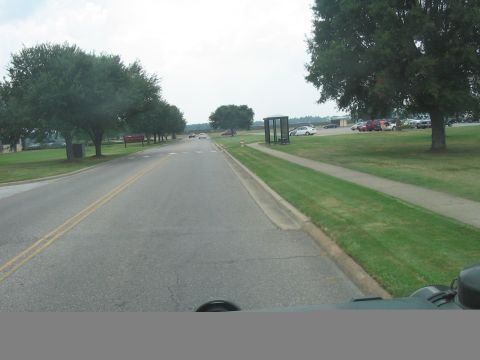 1988 Ford Bronco - Roadside scene with parked cars and trees visible along the road.