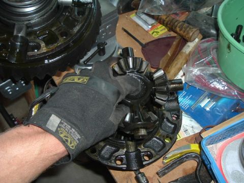 1989 Ford Bronco - A gloved hand carefully places differential gears into a housing, likely during an installation or repair process.
