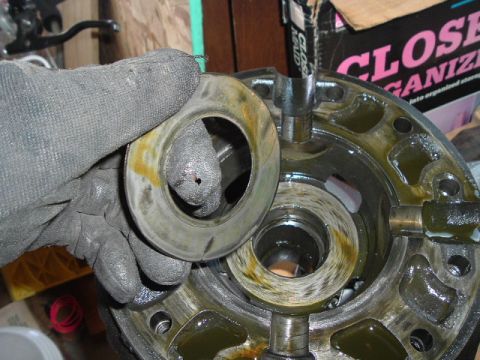 1989 Ford Bronco - A mechanic is holding a bearing race while working on a differential carrier, likely for a vehicle repair.