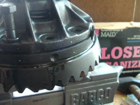1989 Ford Bronco - A differential part is secured in a vise, with a cleaning product box visible in the background.