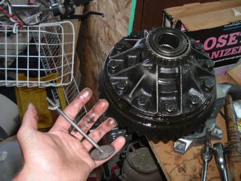 1989 Ford Bronco - A differential carrier and a small tool are shown, likely during a vehicle repair or upgrade process.