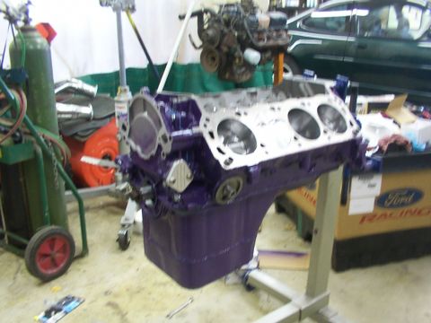 1978 Ford Mustang II - Engine block and assembly in a workshop setting, with a green car in the background.