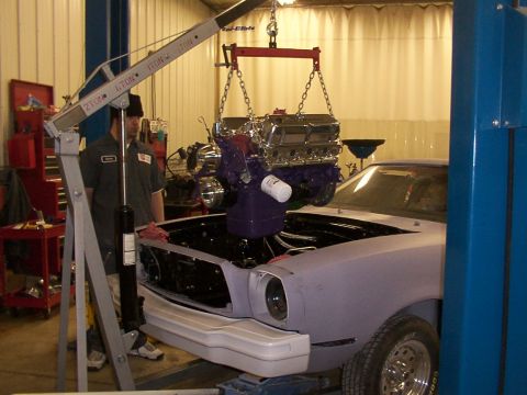 1978 Ford Mustang II - Engine hoist lowering a V8 engine into the engine bay of a 1978 Ford Mustang II.