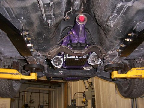1978 Ford Mustang II - The undercarriage of a vehicle reveals a custom purple transmission and exhaust components.