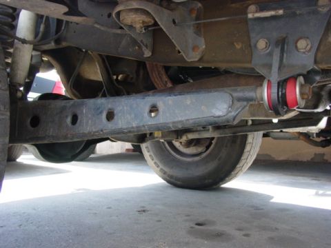 1996 Ford Bronco - The undercarriage of a 1996 Ford Bronco is visible, highlighting its lift kit modifications.
