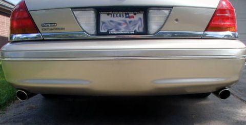 2000 Ford Crown Victoria - Rear view of a gold 2000 Ford Crown Victoria, showing the bumper, dual exhaust tips, and a Texas license plate.