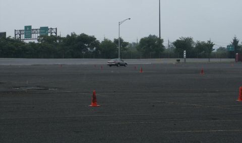 2001 Mercury Grand Marquis - A silver 2001 Mercury Grand Marquis sedan navigates a cone course on a wet asphalt lot.
