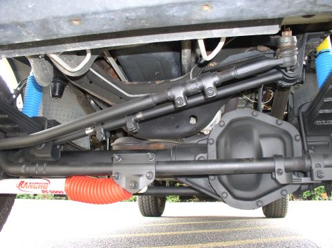 2000 Ford Excursion - front suspension close up. Fab-tech adjustablr trac bar Rancho steering stabilizer sanded and painted flat black