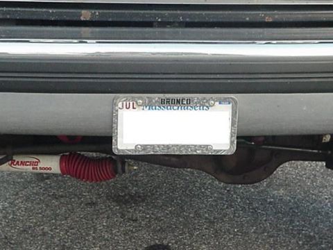 1993 Ford Bronco - A Massachusetts license plate with "BRONCO" is mounted on the rear of a vehicle, with a Rancho shock absorber visible below.