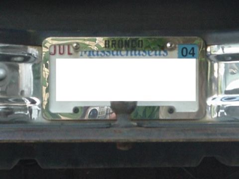 1993 Ford Bronco - The license plate frame reads 'BRONCO' and 'Massachusetts', with a July expiration sticker and a 04 sticker.