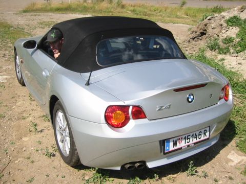 2003 BMW Z4 - A silver 2003 BMW Z4 convertible is viewed from the rear, parked outdoors on a dirt surface.