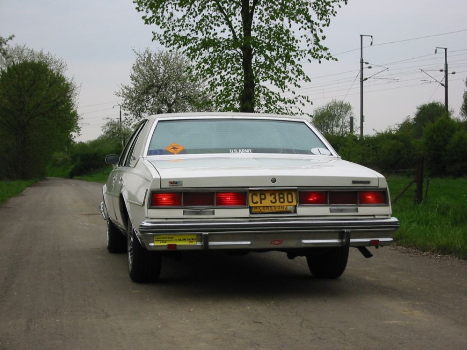 Rear of white Chevrolet sedan with Oregon plate CP 380 on gravel road