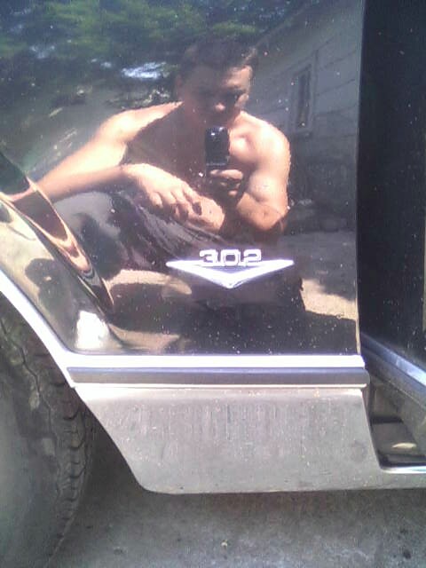 1987 Lincoln Town Car - A man is reflected in the shiny black paint of a car door, which also displays a "302" emblem.