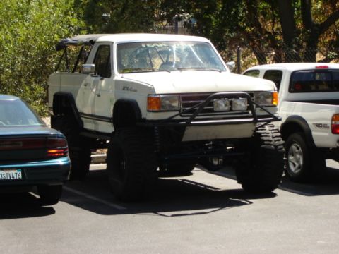 1991 Ford Bronco - This heavily modified white truck, likely from the 1980s, does not match the 1991 Ford Bronco claim.