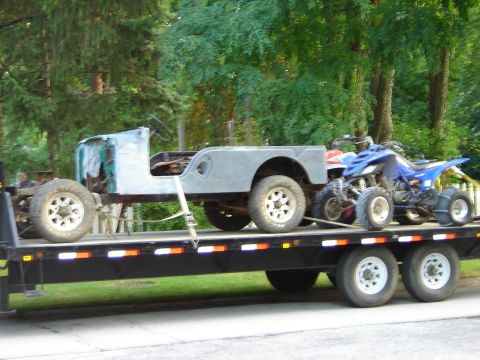 1992 Ford Bronco - A trailer transports a Jeep body and a blue ATV, both appearing to be projects.