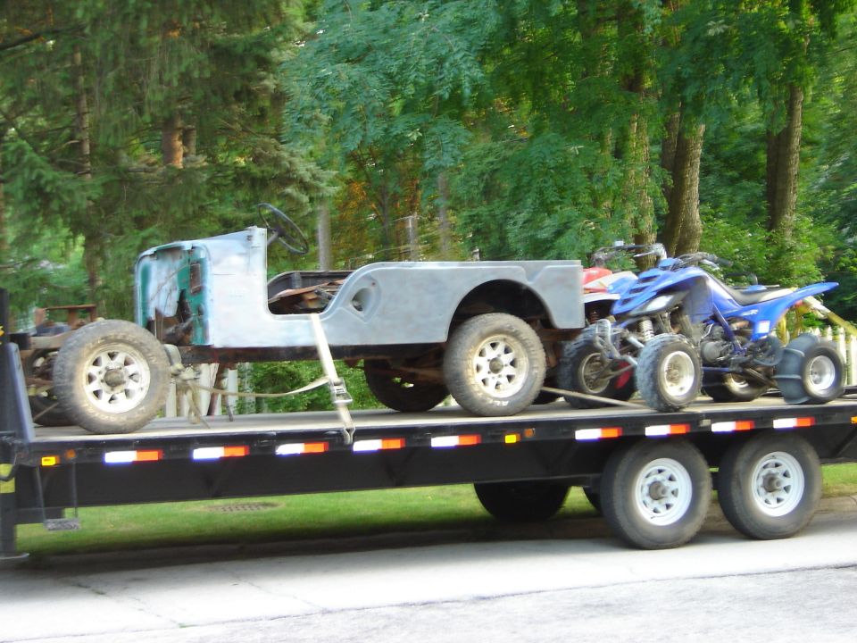 Trailer carrying a Jeep CJ-5 body and a blue ATV