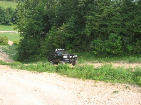 1988 Ford Bronco - This 1988 Ford Bronco navigates a dirt road surrounded by lush greenery.