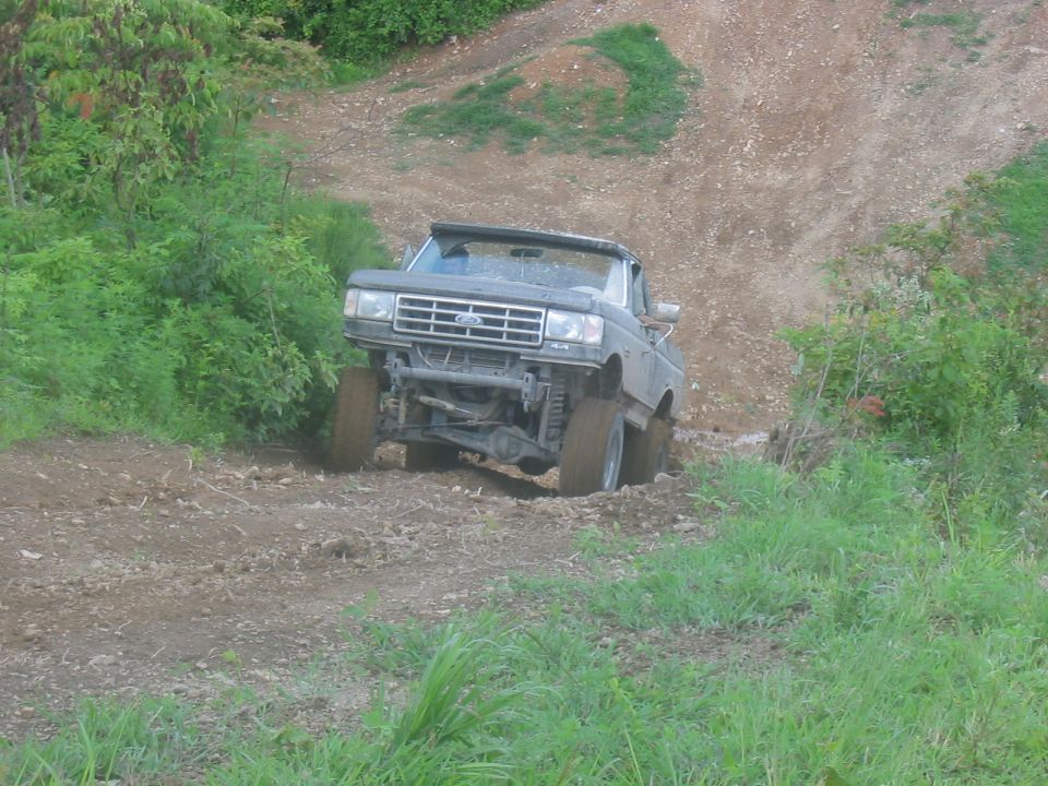 Ford Bronco climbing a dirt hill with large tires