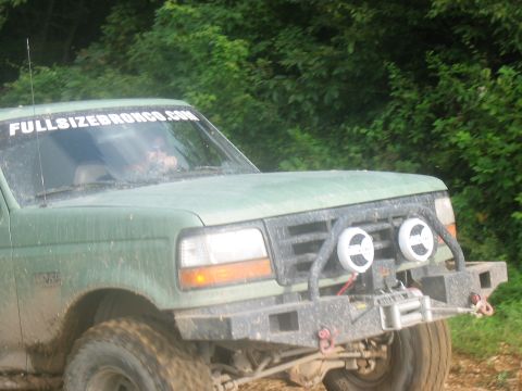 1988 Ford Bronco - Off-road Bronco with custom front end modifications and a website sticker on the windshield.