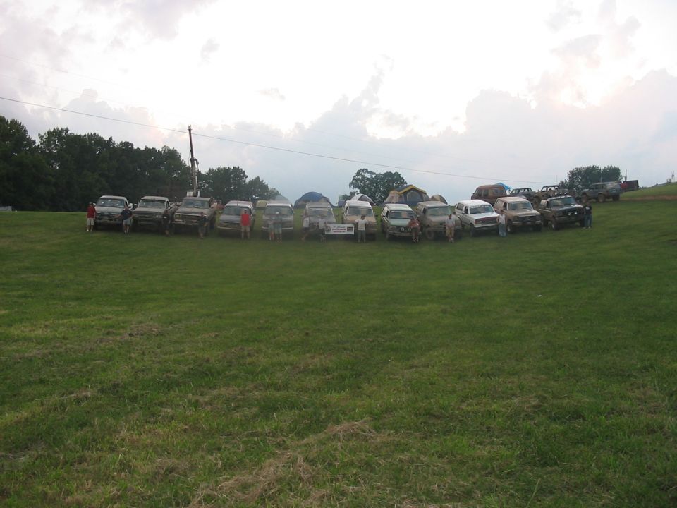 Group of 1988 Ford Broncos and other SUVs parked on a grassy field