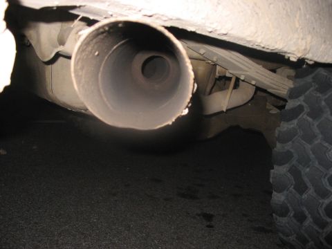 1988 Ford Bronco - Close-up view of a vehicle's exhaust pipe and tire, with visible text from Supermotors.net.