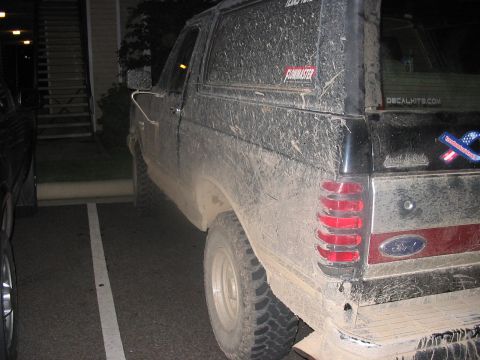 1988 Ford Bronco - This mud-caked Ford Bronco is parked in a parking lot, showing off its off-road adventures.