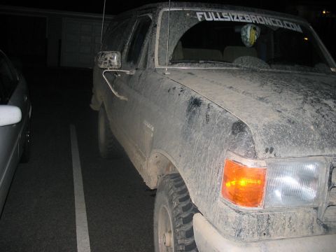 1988 Ford Bronco - A dirty 1987 Ford Bronco is parked at night, showing its front and side profile.