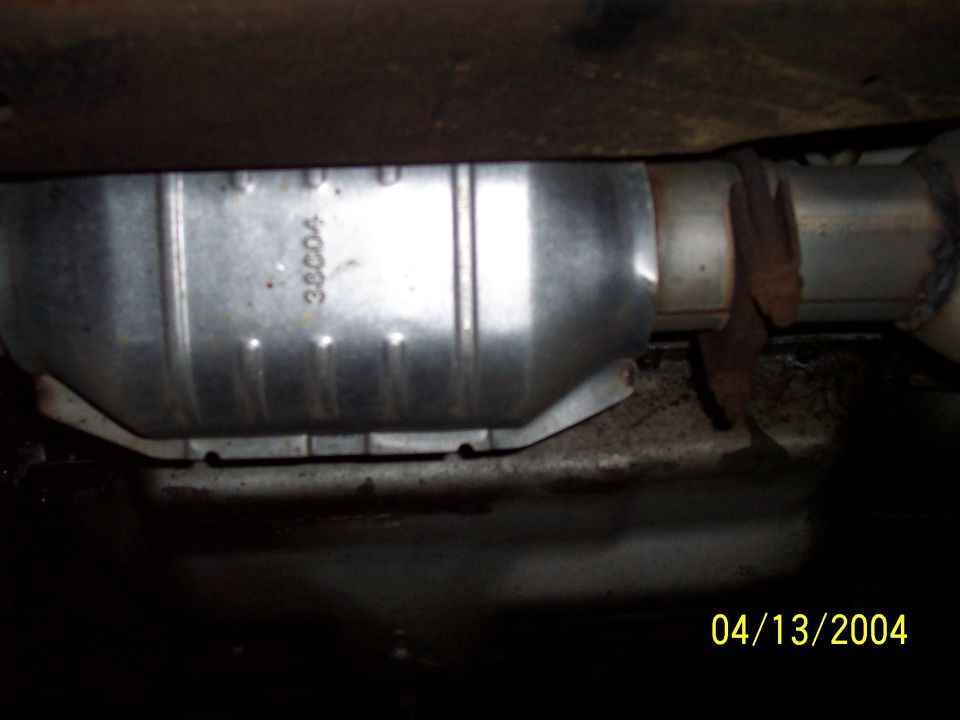 Catalytic converter with part number 30004 visible, attached to exhaust pipe