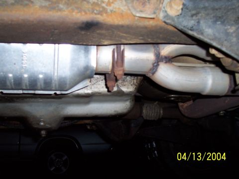 1994 Ford Bronco - Close-up of a vehicle's exhaust system components, including a catalytic converter.
