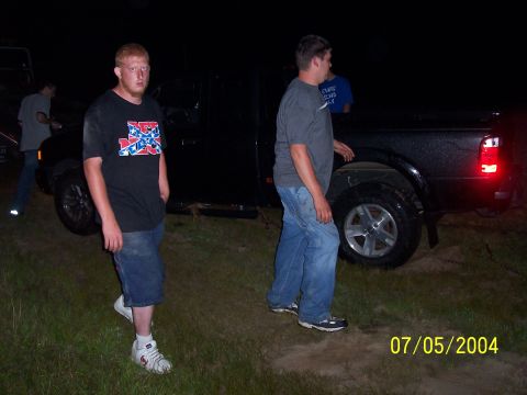 1994 Ford Bronco - Two men stand next to a black pickup truck in a grassy area at night.
