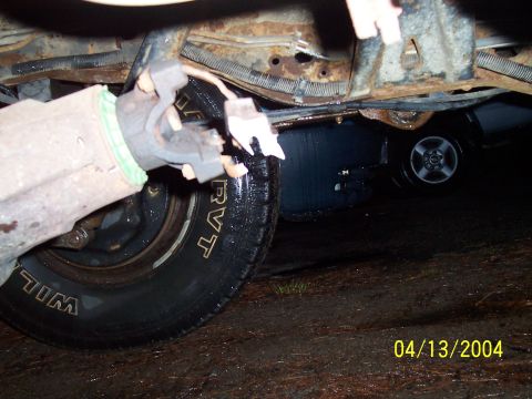 1994 Ford Bronco - A damaged driveshaft yoke is visible on a vehicle, with another vehicle's wheel in the background.